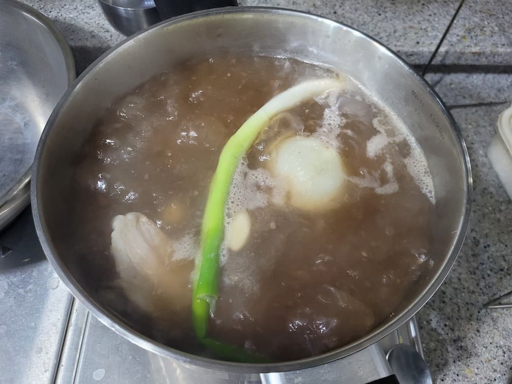 삼겹살 + 대파·양파가 함께 끓고 있는 냄비