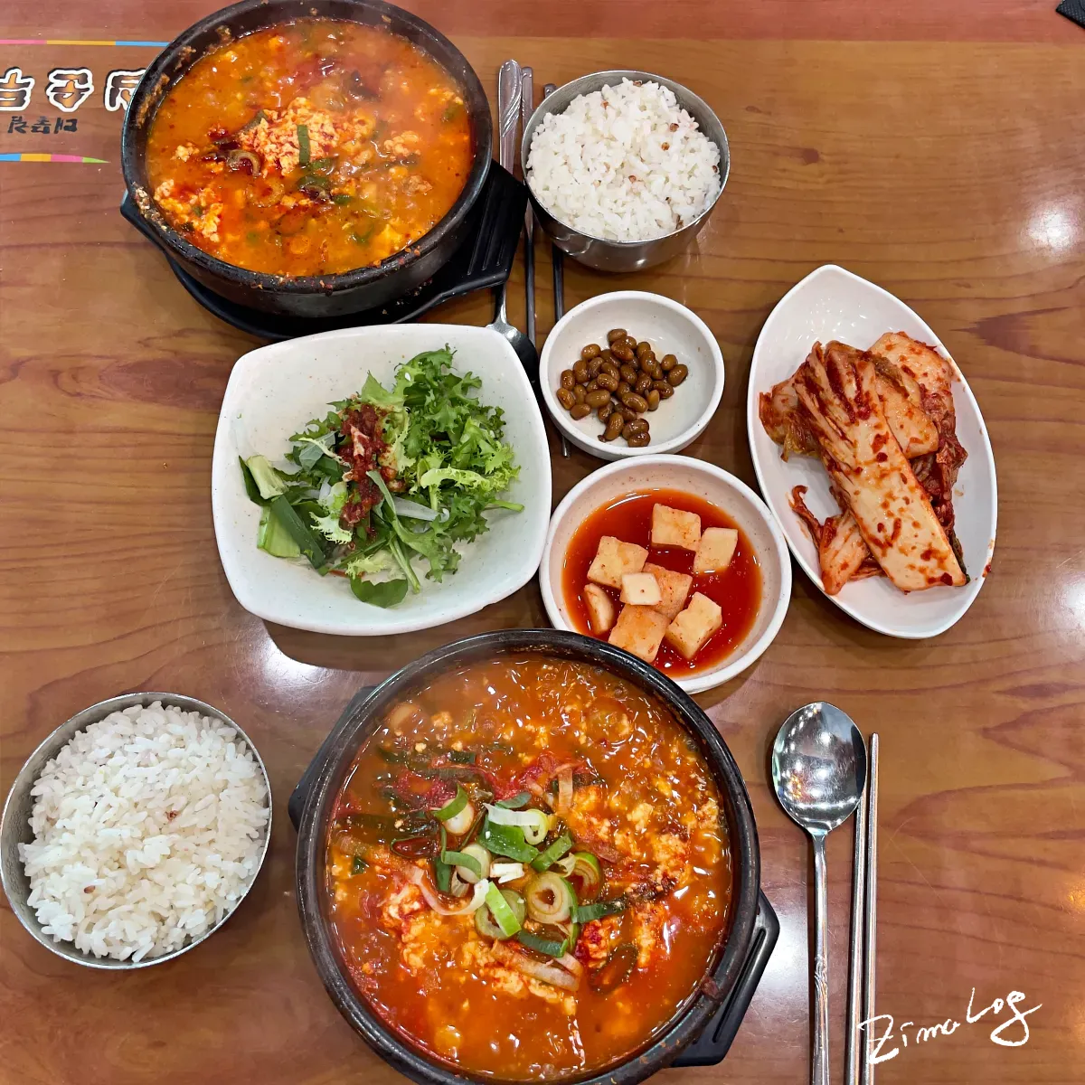 화심순두부에서 주문한 바지락 순두부찌개와 화심 순두부찌개, 그리고 밑반찬이 테이블에 놓여 있음