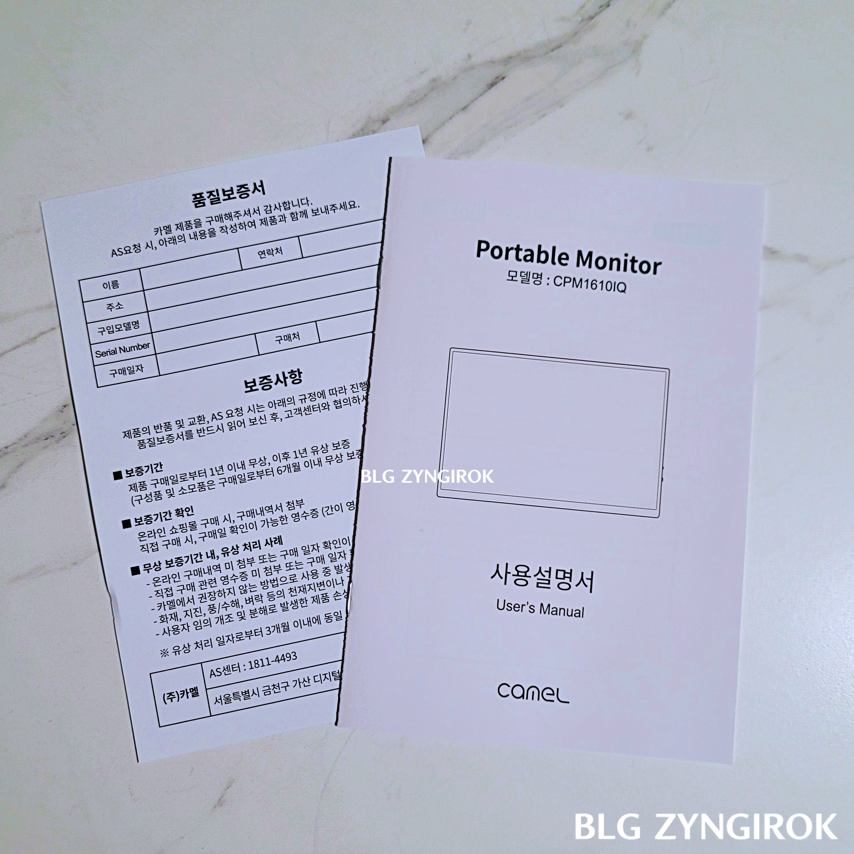 한글 품질보증서와 사용설명서가 테이블 위에 놓여있다.