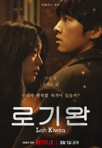 영화 로기완의 남녀 주인공이 서로 마주보고 서서 생각에 잠긴 듯한 표정을 짓고 있다.