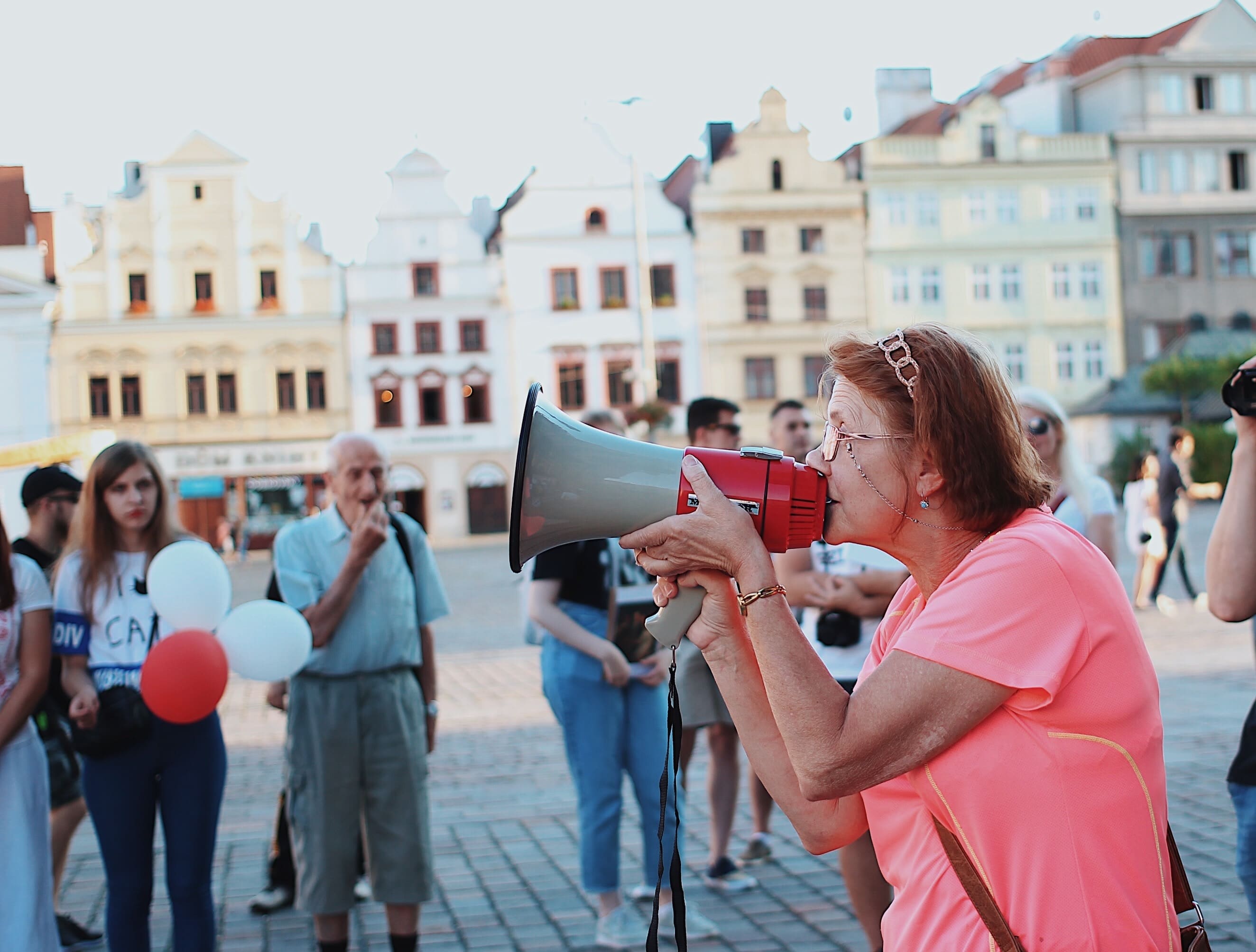 An elderly woman talking to people through a megaphone