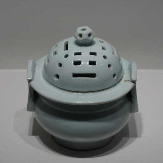 푸른빛이 돌며 뚜껑에 직사각형과 동그라미 구명이 뚫린 달항아리 전시 모습