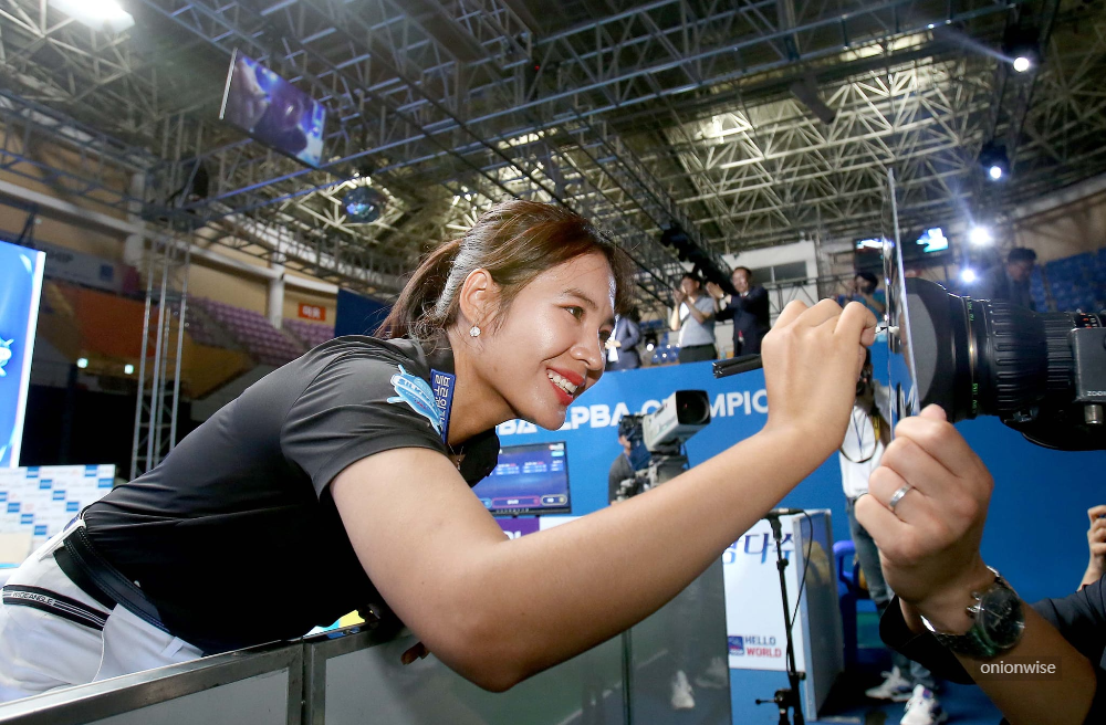 우승후 카메라 렌즈 필터에 우승기념 사인을 하고 있는 스롱피아비