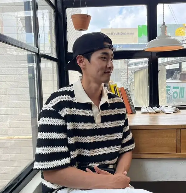 솔로지옥 3 - 흰색바탕 검정색 가로줄무늬 반팔티를 입고 검정색 챙모자를 쓴채 옆을보며 미소짓는 손원익