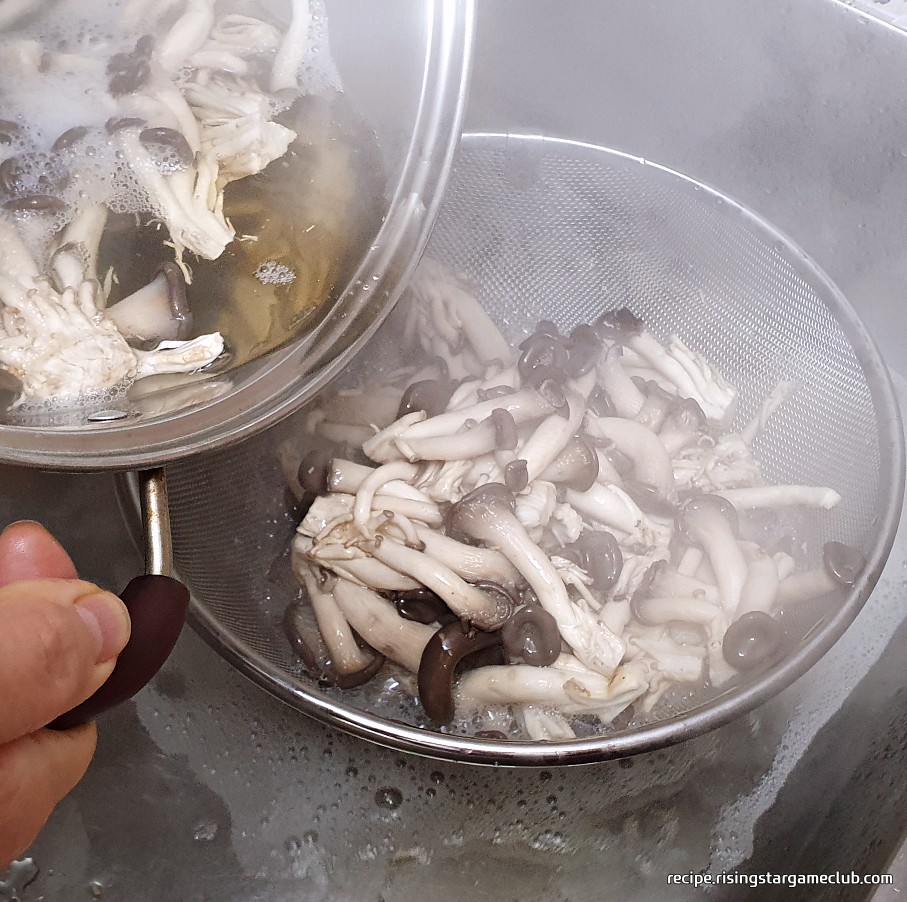 데쳐진 뜨거운 느타리버섯을 체에 거르는 사진