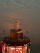 난로. 빨간 불꽃이 일어 따뜻한 느낌을 준다. 난로 위에는 주전자와 그 안에 일본식 술병이 놓여있다.