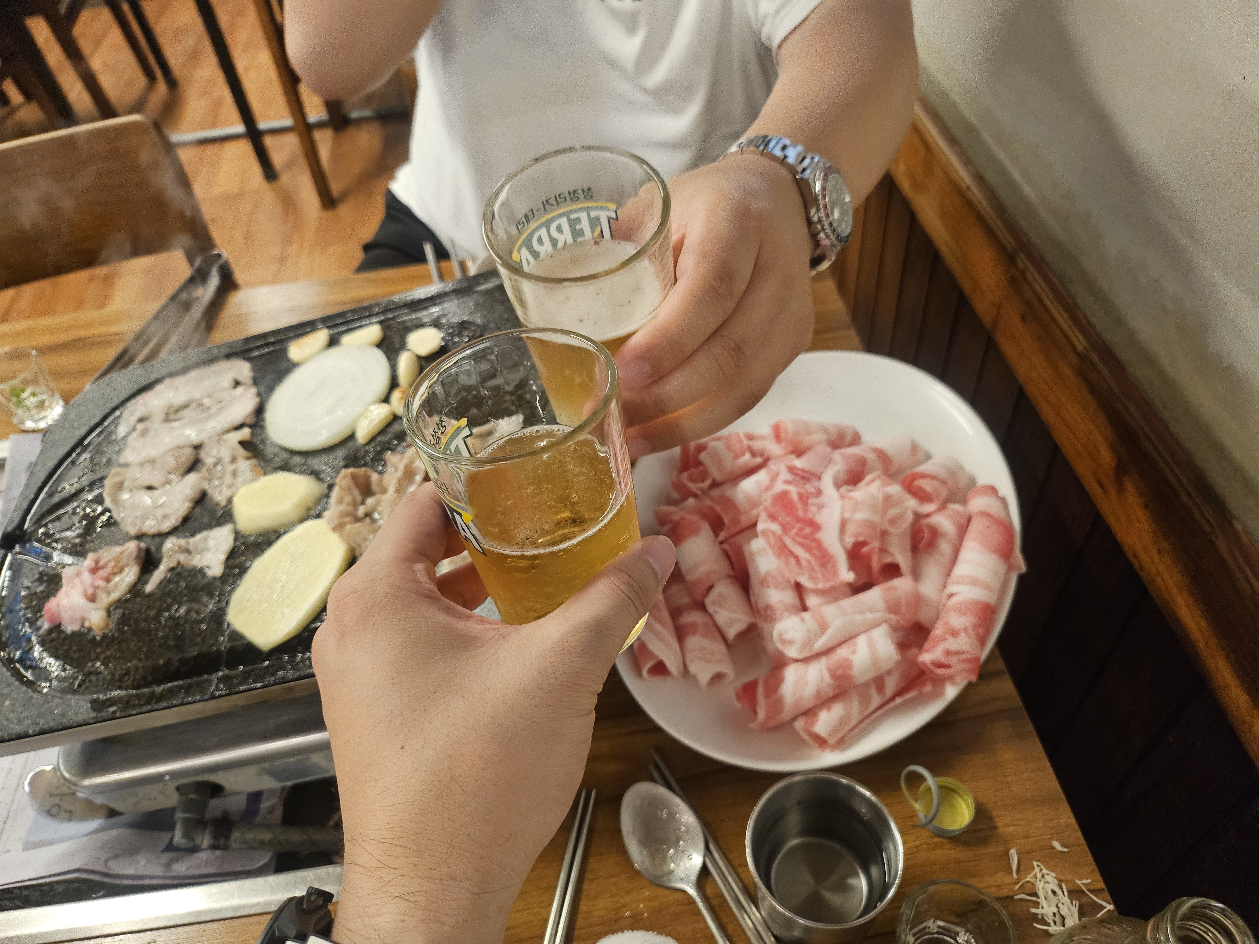 두 사람이 맥주잔을 들고 건배하는 모습