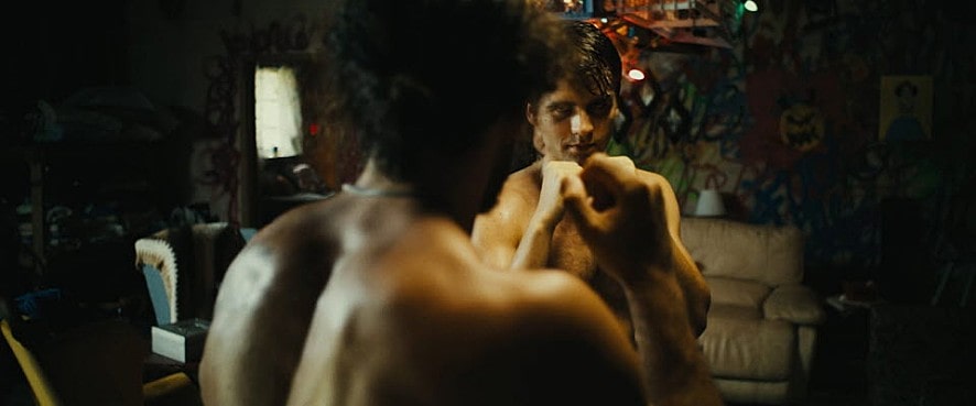 거울을 보고 주먹다짐 하는 남자의 모습