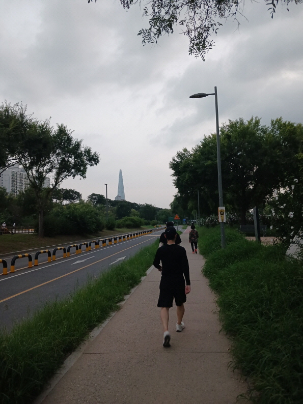 잠실 한강공원 산책로에서 낮 시간 빠르게 걷기 운동을 하는 사람들