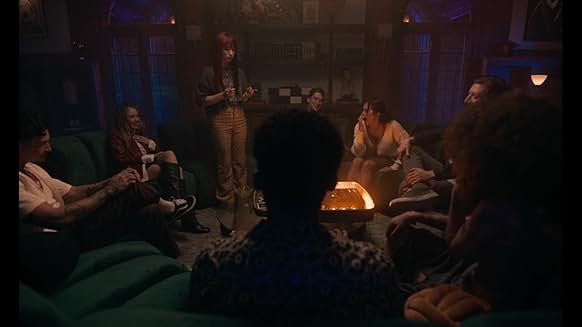 영화 It’s What’s Inside에서 친구들이 원형 소파에 모여 게임을 시작하는 장면