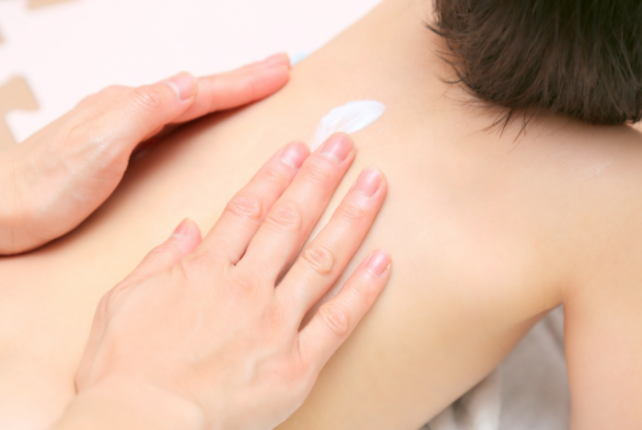 등에 로션을 바르는 아기