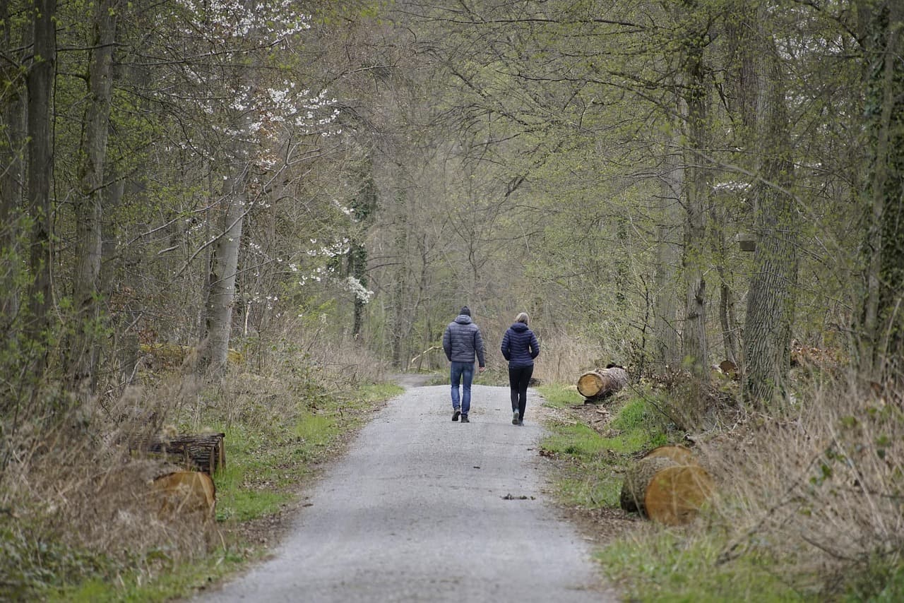 자연 속에서 거리감을 유지하며 걷는 커플의 모습