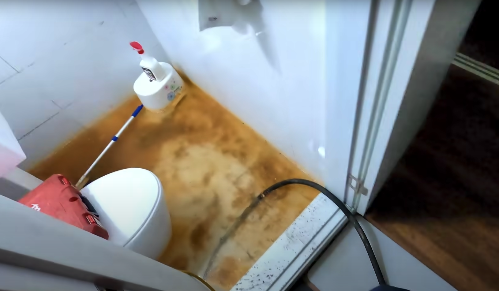 화장실에 주황색 오물과 많은 물이 역류해있다