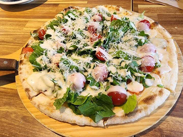 루꼴라와 방울토마토가 토핑된 피자