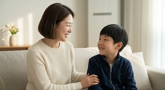 엄마가 아이 옆에 앉아 따뜻하게 말을 걸고 있는 거실 장면