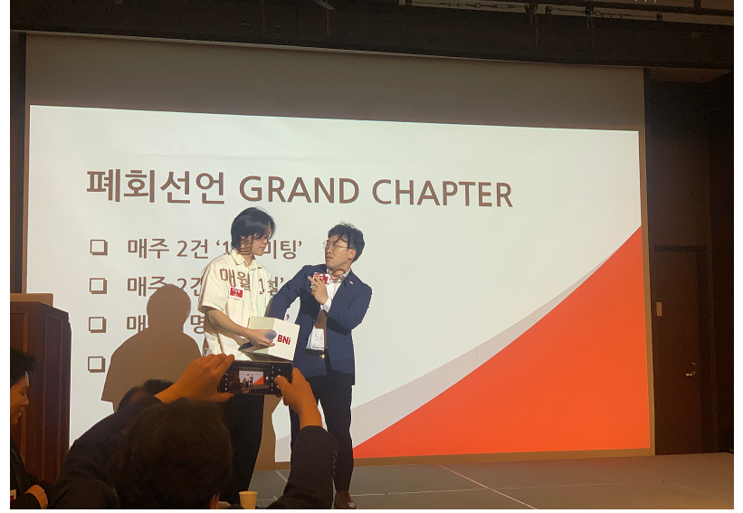 어스플랜트 이남훈 대표님과 삼도회계법인 홍세기 회계사님이 일어서서 추첨함에 손을 넣고 선물 추첨을 하고 있습니다.