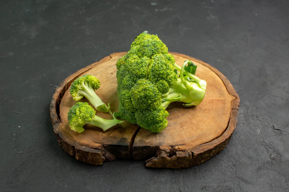 신선한 브로콜리 한 송이가 나무 도마 위에 놓인 모습