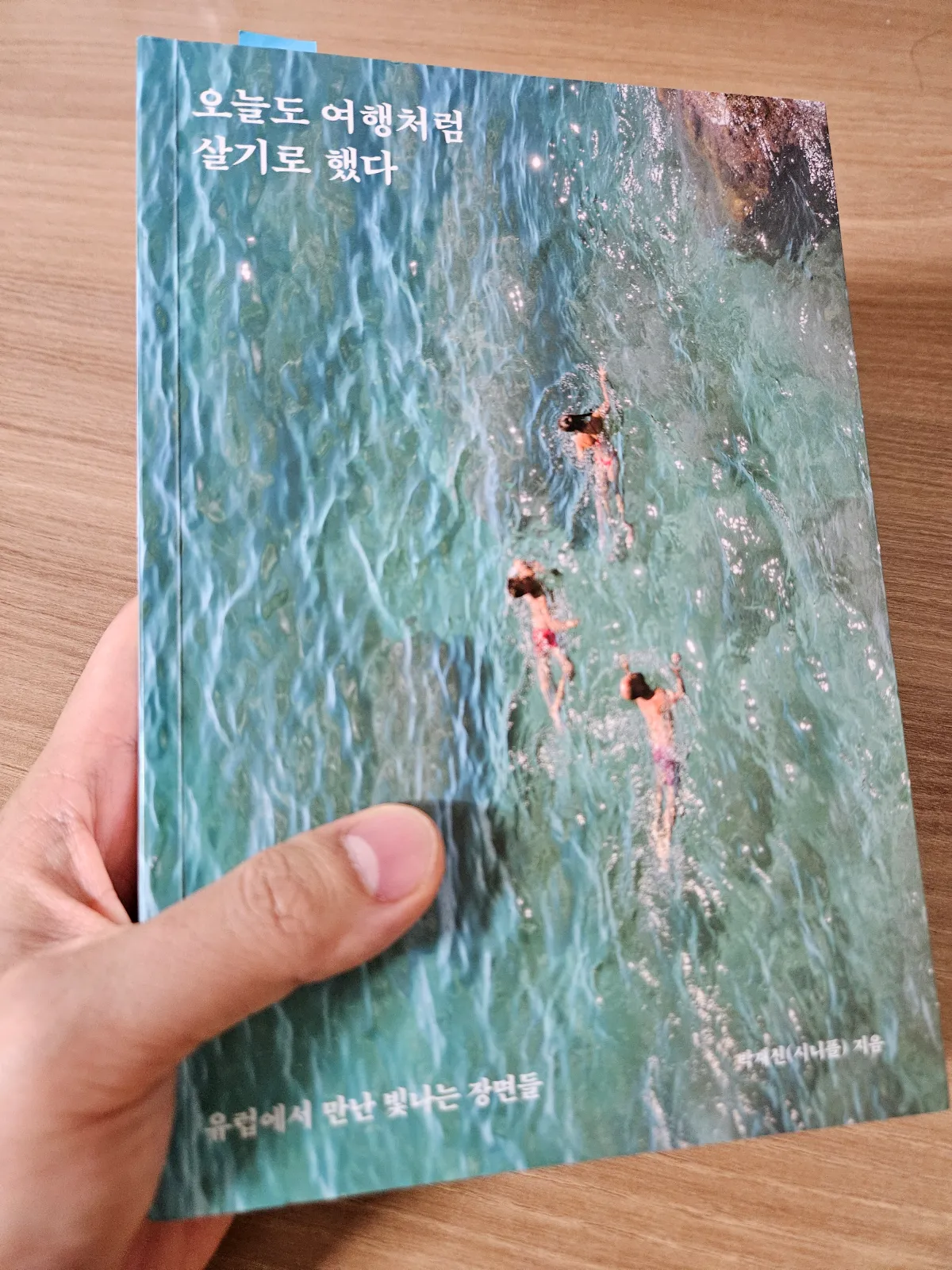 오늘도-여행처럼-살기로-했다-책을-들고-있는-모습