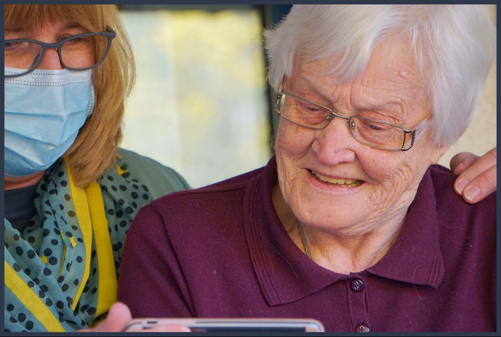 핸드폰을 보며 웃고 있는 노인