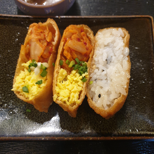 김치와 계란이 올라가있는 유부초밥 2개와 초밥만 있는 유부초밥 1개