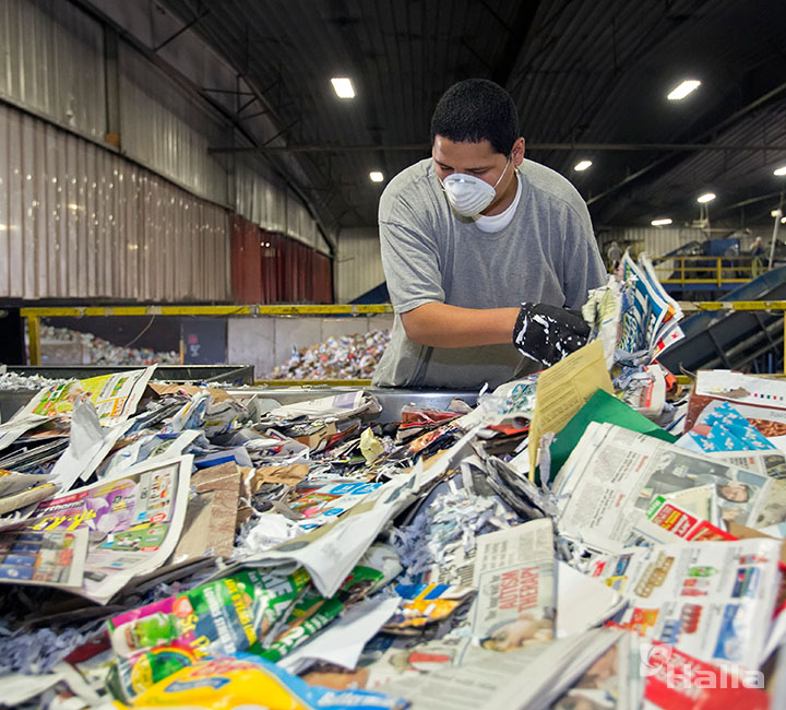 버려진 종이를 재질에 따라 분류하는 노동자의 모습
