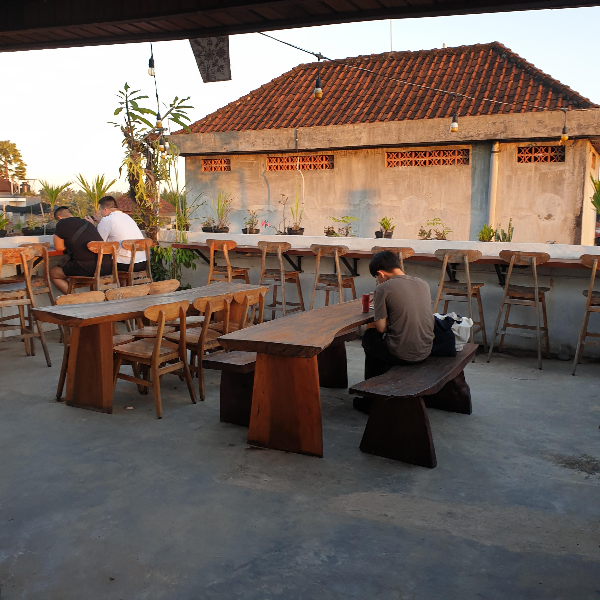 루프탑에 테이블들이 보인다. 중앙 긴 테이블과 가장자리를 따라 배열된 1인석들. 내부에는 3명의 고객이 앉아있다.