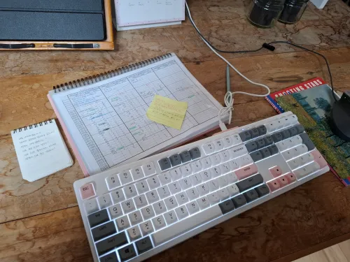 작가의 책상 위 키보드와 메모지: 메타현실 창조를 위한 집필 공간 (Original Photo of Writer's Desk with Keyboard and Notes)
