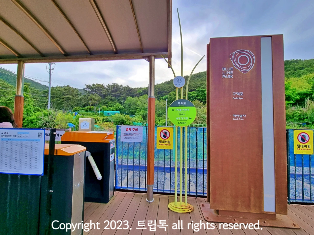 왼쪽에 초록색 개찰구가 있고 오른쪽에 갈색으로 역이름이 적혀있다.