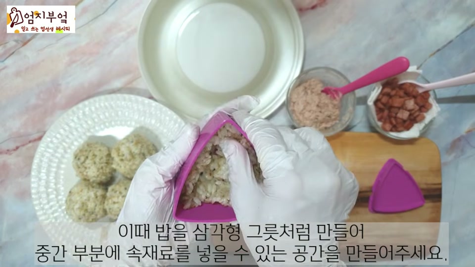 삼각김밥 틀에 밥과 속재료를 넣는 장면