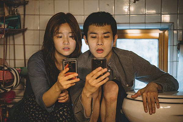 영화 '기생충'의 남매가 화장실에서 스마트폰을 보는 장면
