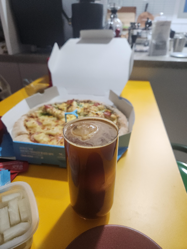 피자와 함께 추출한 아메리카노가 얼음컵에 담겨 있다.