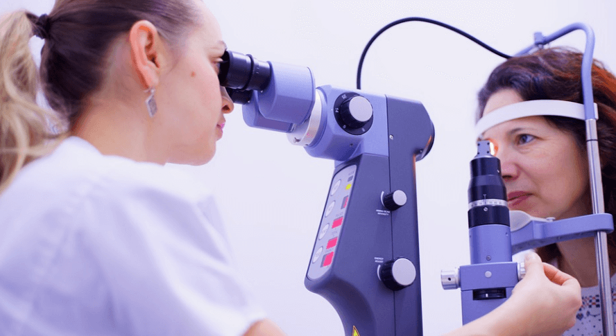 안구 검사를 하고 있는 의사와 검사를 받고 있는 여성