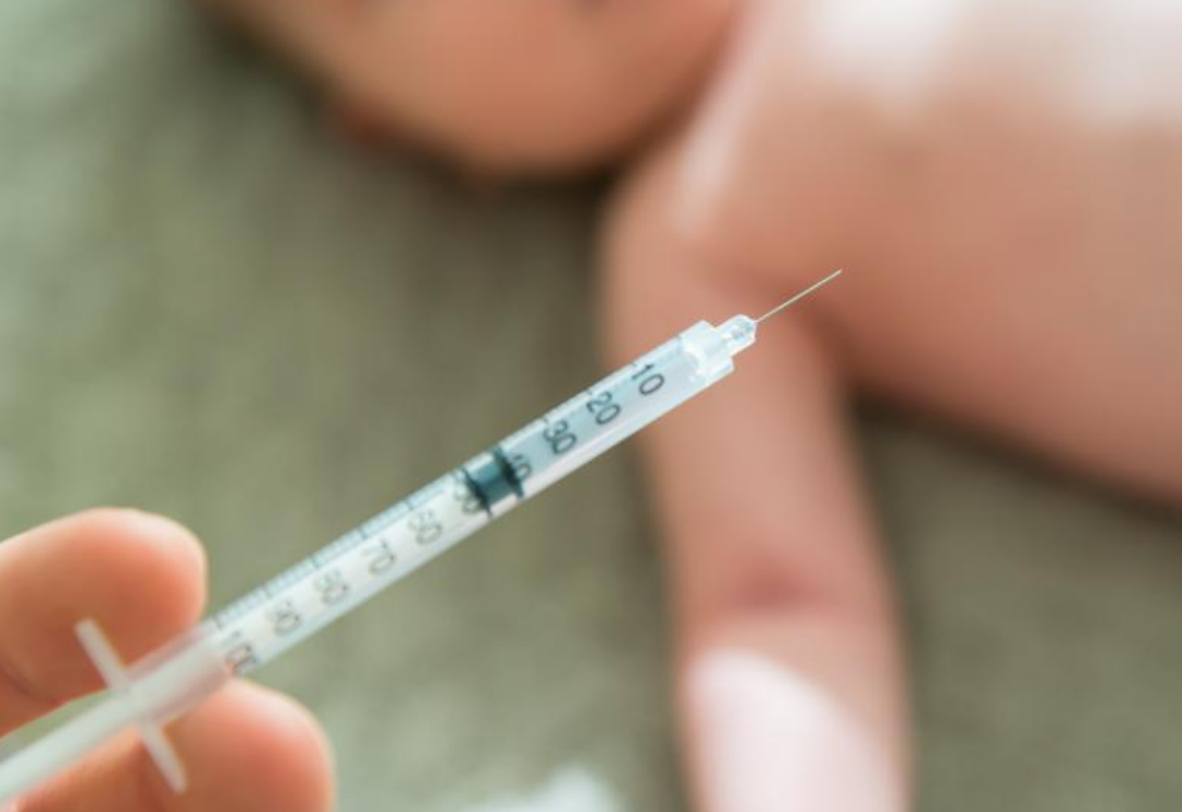 작은주사기와 갖난아이가 누워있다.