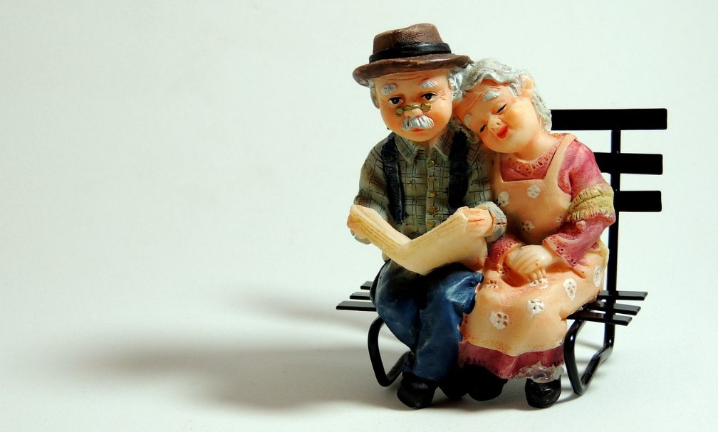 노부부가 벤치에 앉아 편안한 표정으로 시간을 보내는 이미지입니다.