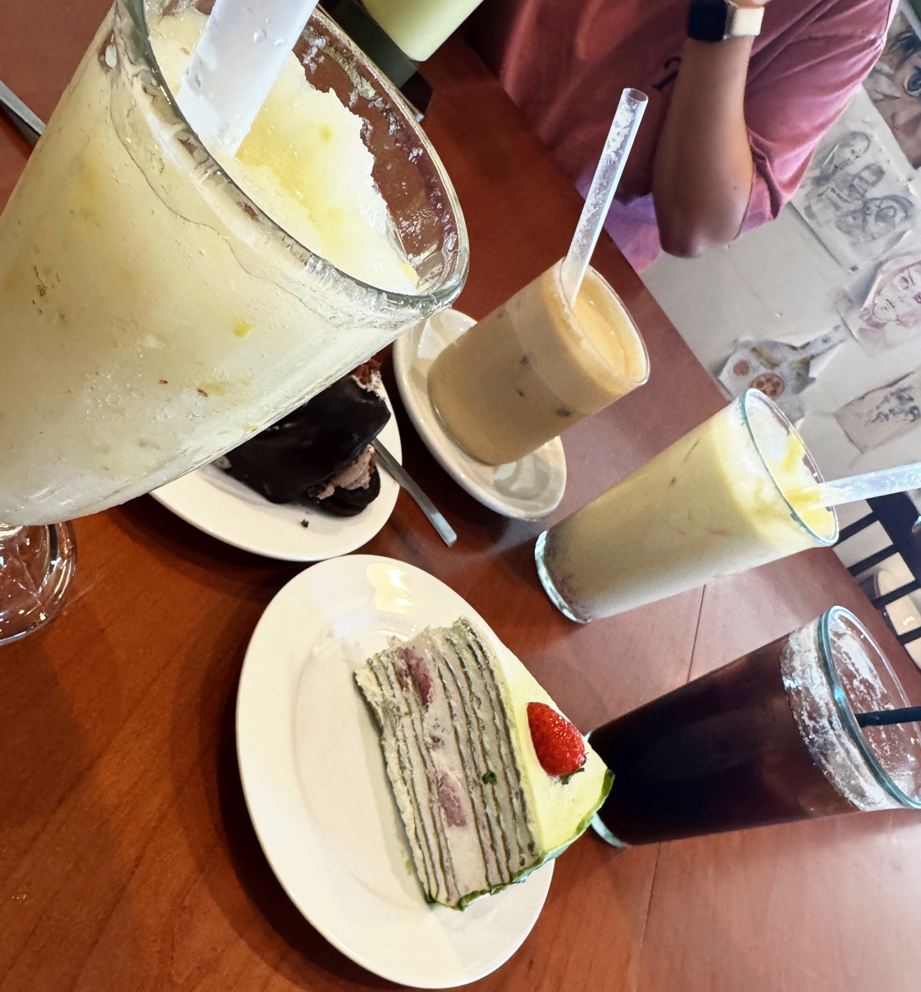 정자동 엑성프로방스 카페 테이블 &ndash; 레몬청 스무디&amp;#44; 아이스 아메리카노&amp;#44; 아이스 라떼와 함께 말차 크레이프 케이크&amp;#44; 초코 케이크가 놓인 모습