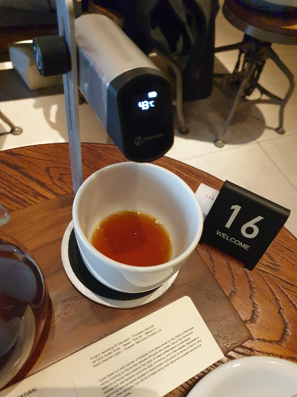 온도계가 43도를 가르키고 컵에는 커피가 조금 남아 있다.