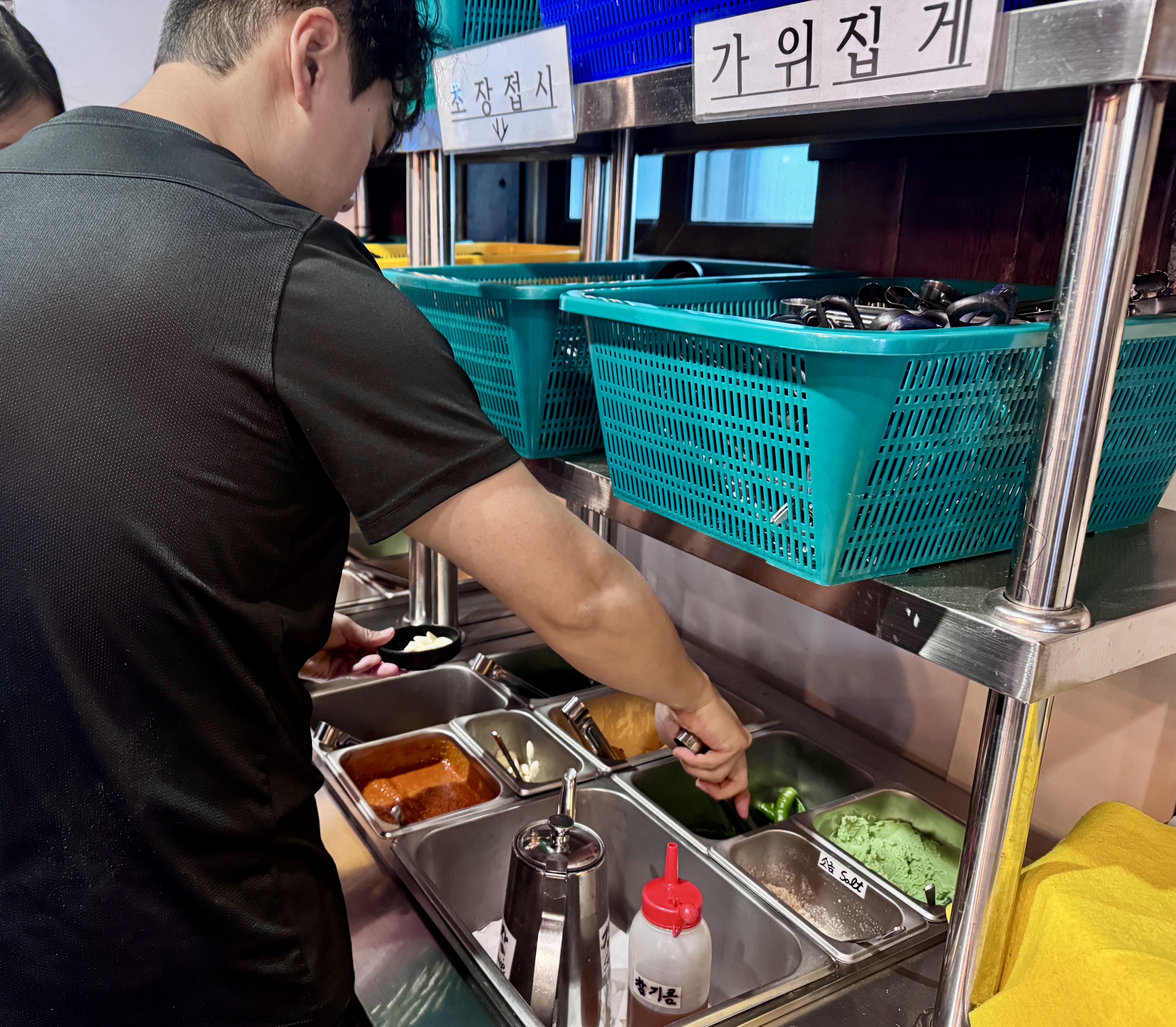 강릉 경포대 화니조개 셀프바에서 밑반찬과 집게를 가져오는 모습
