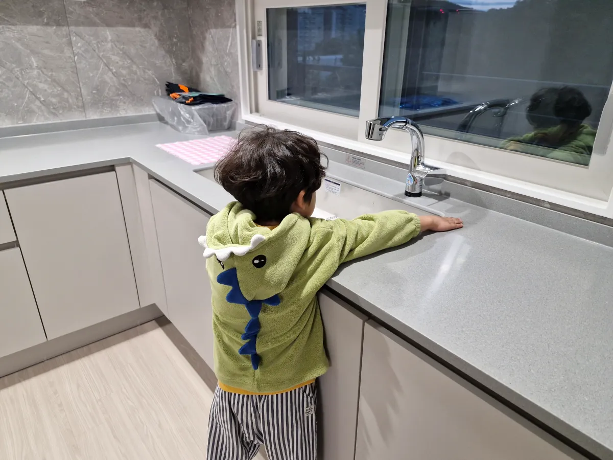 아이가-주방에서-물이-나오는지-틀어보고-있다