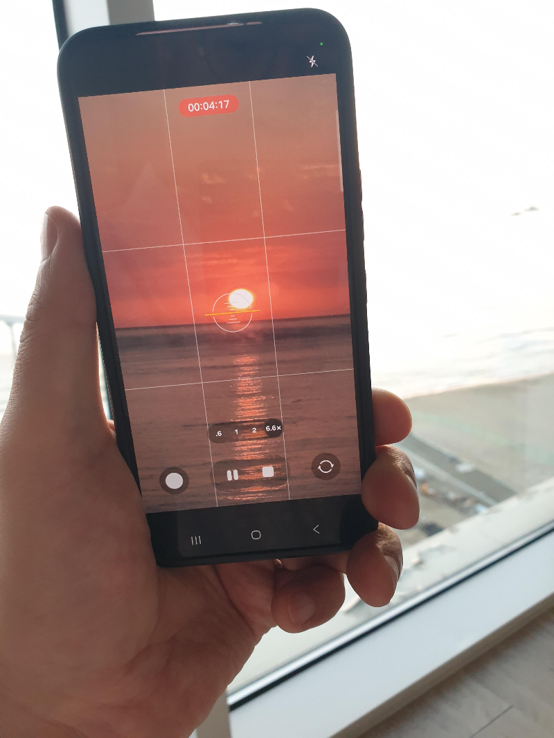 핸드폰으로 해돋이 영상을 재생 중이다.