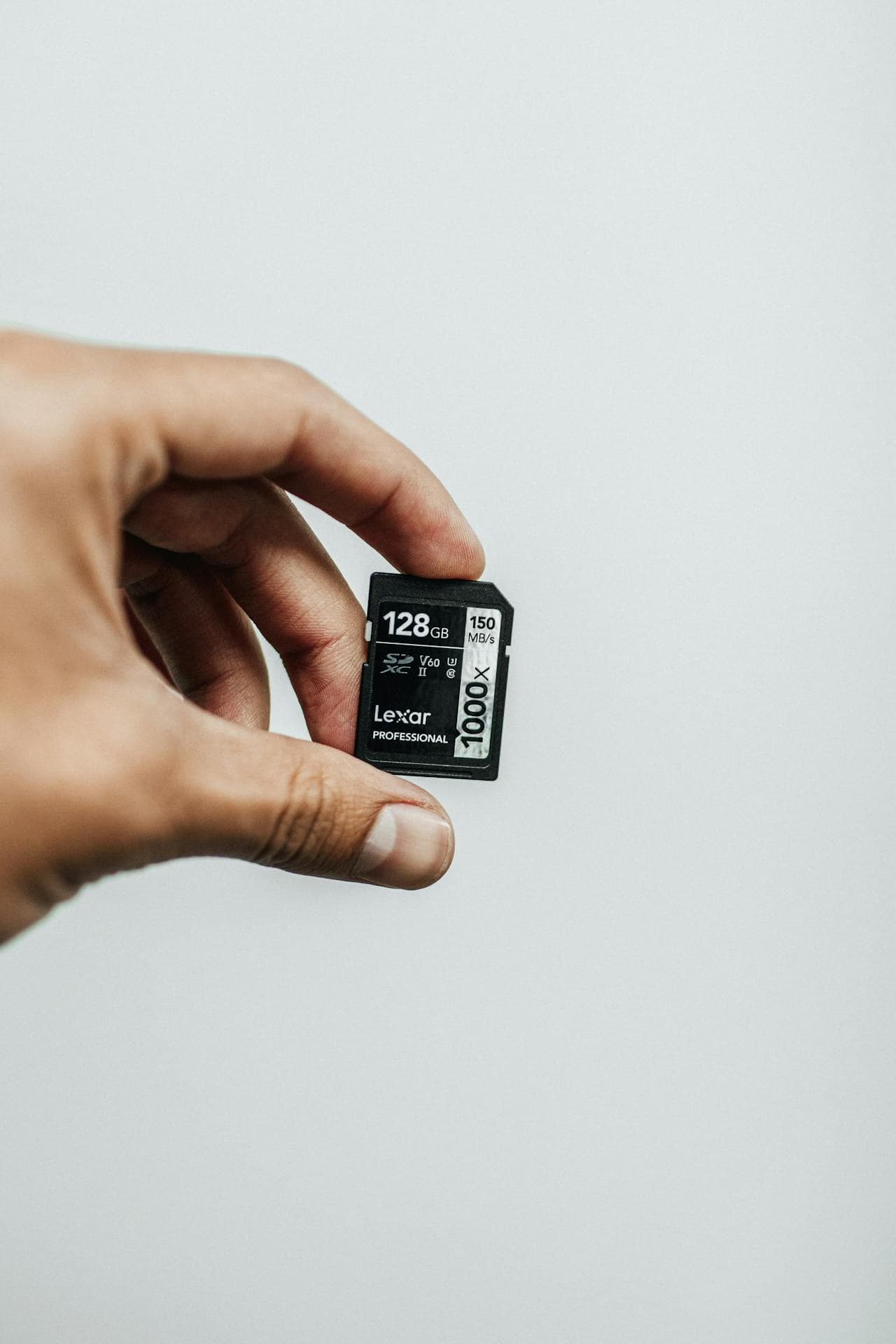 손에 들린 128GB SD 메모리카드(LEXAR) 클로즈업