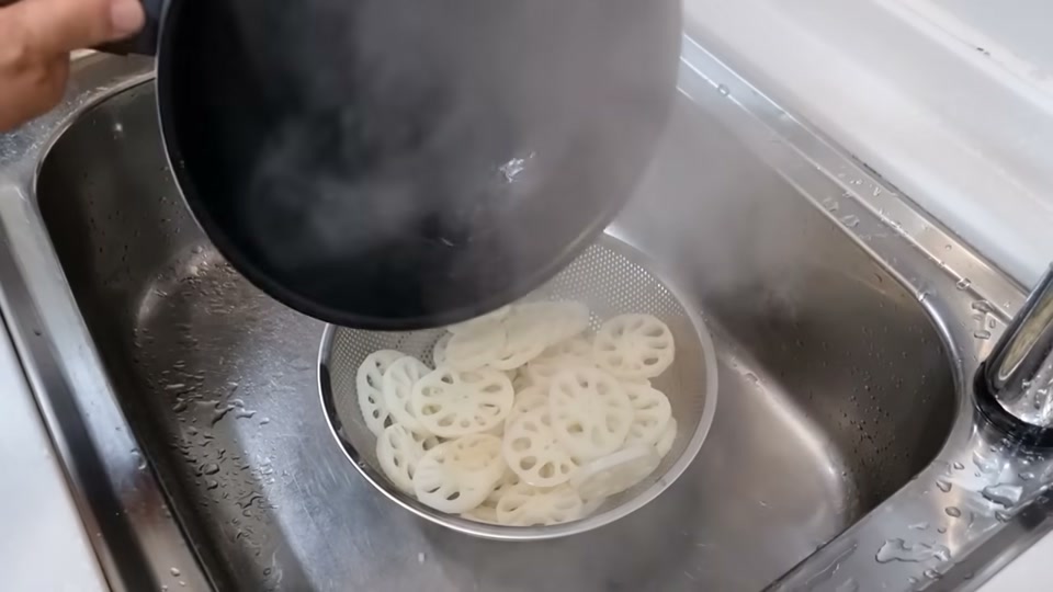 데친 연근을 찬물에 헹구는 장면