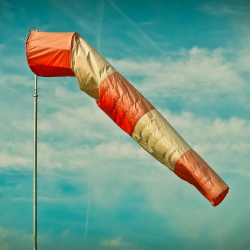 Cyclist riding in strong wind conditions demonstrating proper balance and control technique