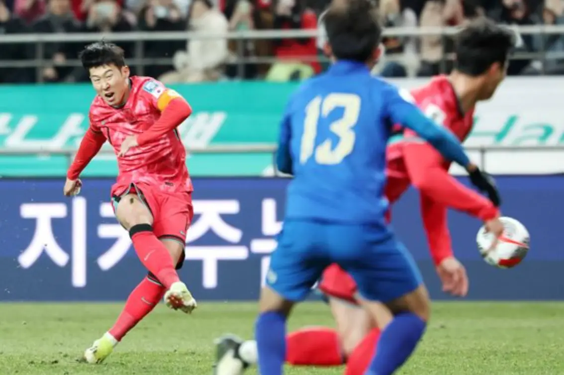 태국전- 붉은 유니폼을 입은 손흥민이 공을 힘껏차고 이를 막는 파란유니폼의 태국선수