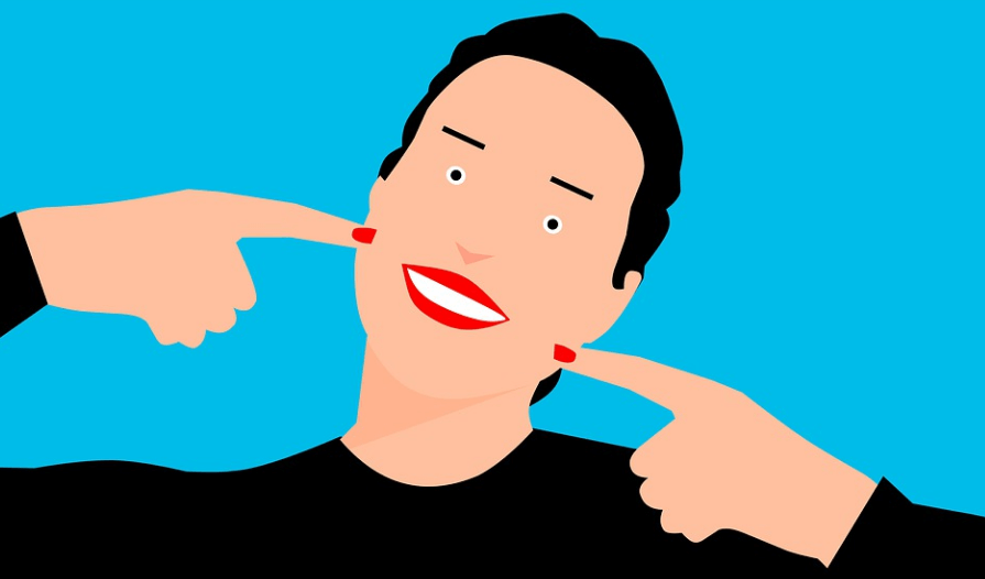 양 볼에 손가락을 올려 놓고 치아가 보이도록 환하게 웃고 있는 여성