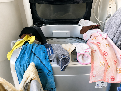 비 오는 날 세탁기 위에 바로 꺼낸 빨래를 널어두는 생활 모습