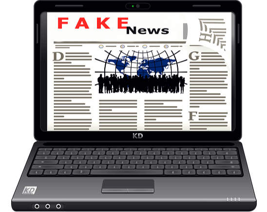 검정 노트북 화면에 신문기사가 나와 있고, 신문 맨 위에는 빨간 글씨로 FAKE NEWS라고 적혀있다.
