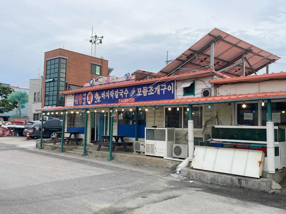 선향횟집 식당외부 모습 파란색 간판에 선향 자연산회 바지락칼국수, 조개구이 라고 쓰여져 있는 모습