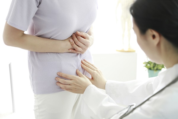 복통이 심한 여성을 진료하는 의사