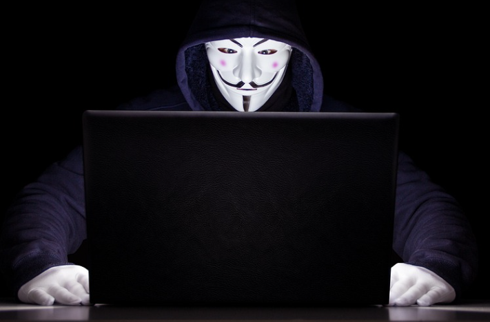 가면 쓴 사람이 컴퓨터 하고 있는 모습