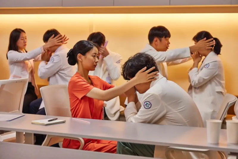 오렌지색 간호사 복장을 하고 앉아 있는 드라마 정신병동에도 아침이 와요의 민들레 캐릭터